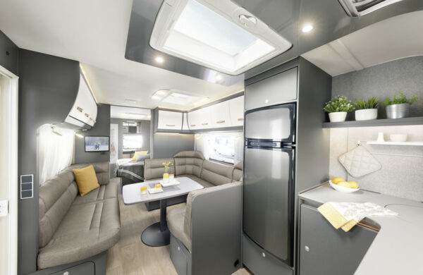Dethleffs Caravan Innenraum: Sitzbank mit Tisch, Kühlschrank und Küchennische