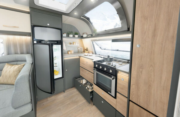 Dethleffs Caravan Innenraum: Sitzbank mit Tisch, Kühlschrank und Küchennische